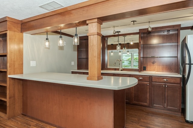 kitchen featuring sink, stainless steel refrigerator, decorative light fixtures, ornate columns, and dark hardwood / wood-style flooring