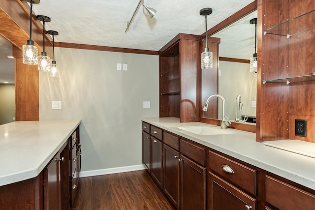 kitchen featuring decorative light fixtures, rail lighting, sink, dark hardwood / wood-style floors, and a textured ceiling