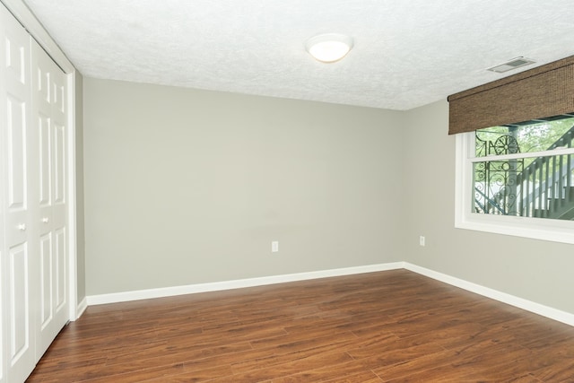 unfurnished room featuring a textured ceiling and hardwood / wood-style floors