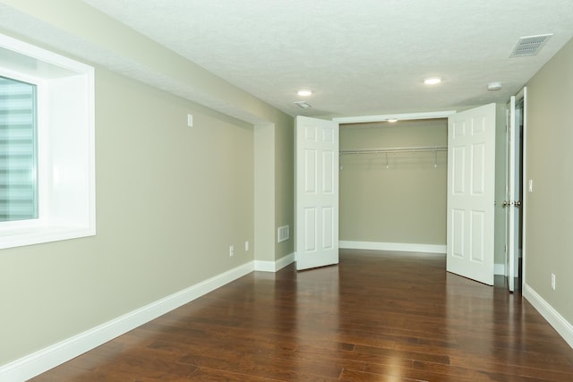 unfurnished bedroom featuring a textured ceiling, hardwood / wood-style flooring, and a closet