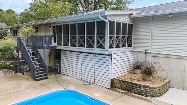 view of swimming pool featuring a sunroom, a deck, and a patio area