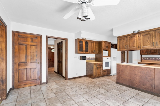 kitchen with ceiling fan, white appliances, and light tile patterned floors