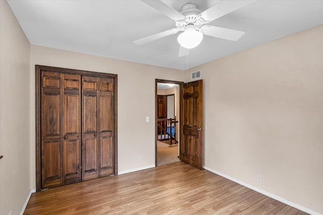 unfurnished bedroom featuring light hardwood / wood-style floors, a closet, and ceiling fan