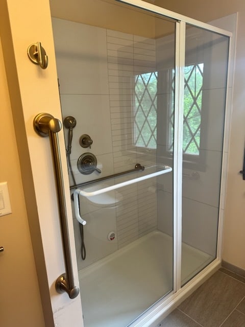 bathroom featuring tile patterned flooring and an enclosed shower