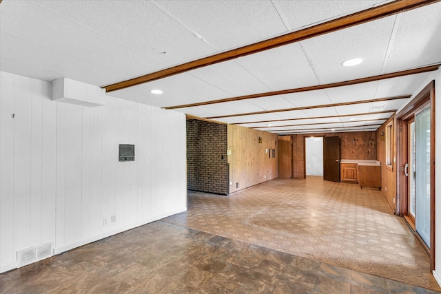 unfurnished room with wood walls and tile patterned floors