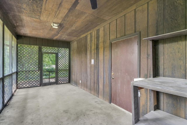 unfurnished sunroom featuring ceiling fan