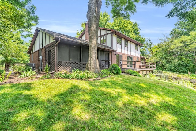 back of property featuring a sunroom and a yard