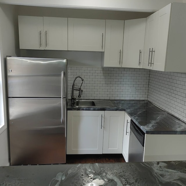 kitchen with white cabinetry, appliances with stainless steel finishes, sink, and backsplash