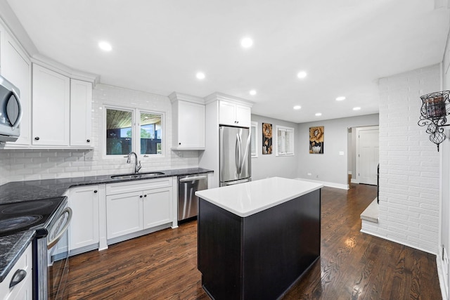 kitchen with tasteful backsplash, a center island, dark hardwood / wood-style flooring, appliances with stainless steel finishes, and sink