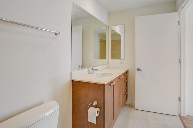 bathroom with tile patterned flooring, vanity, and toilet