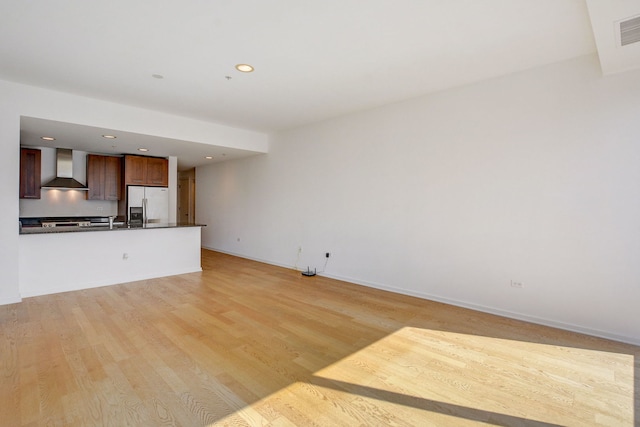 unfurnished living room with sink and light hardwood / wood-style floors