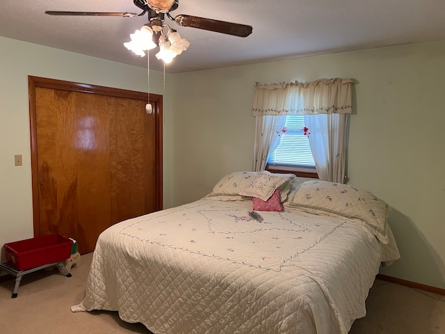 carpeted bedroom featuring ceiling fan and a textured ceiling