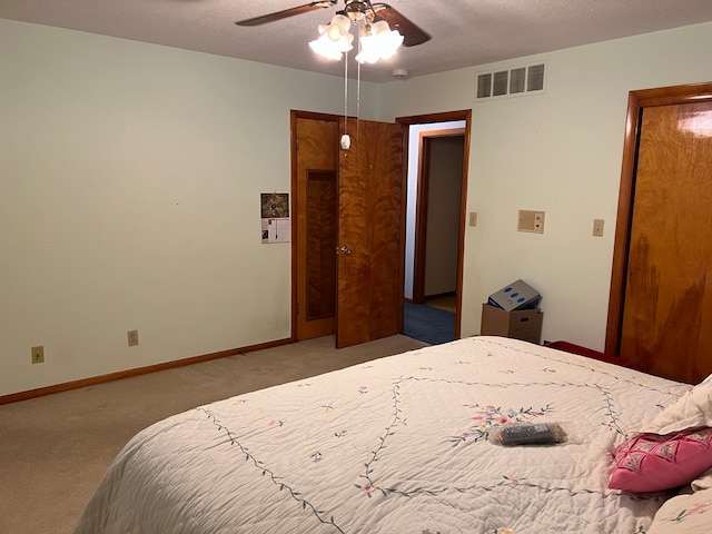 carpeted bedroom with ceiling fan and a textured ceiling