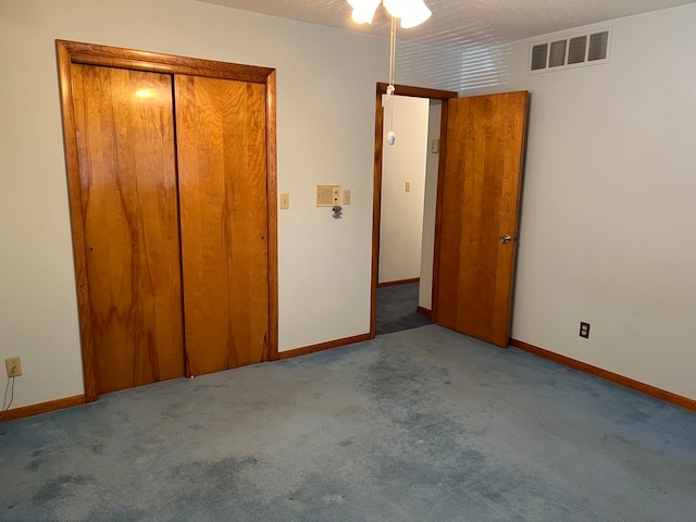 unfurnished bedroom with light colored carpet, a textured ceiling, and a closet