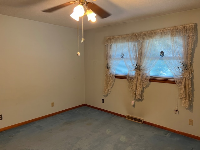 carpeted spare room featuring ceiling fan and a textured ceiling