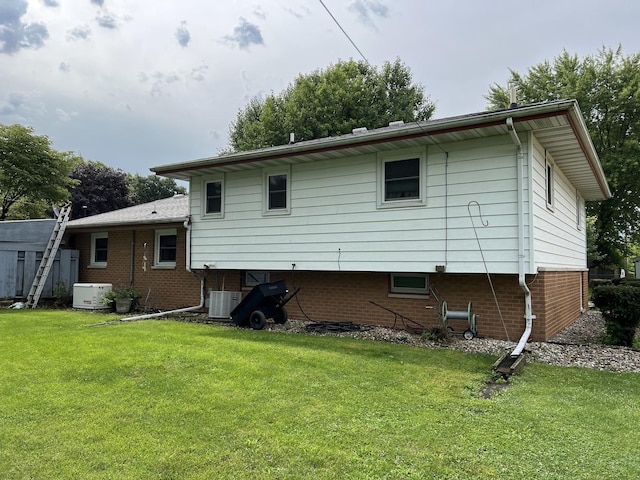 rear view of property with a yard and brick siding