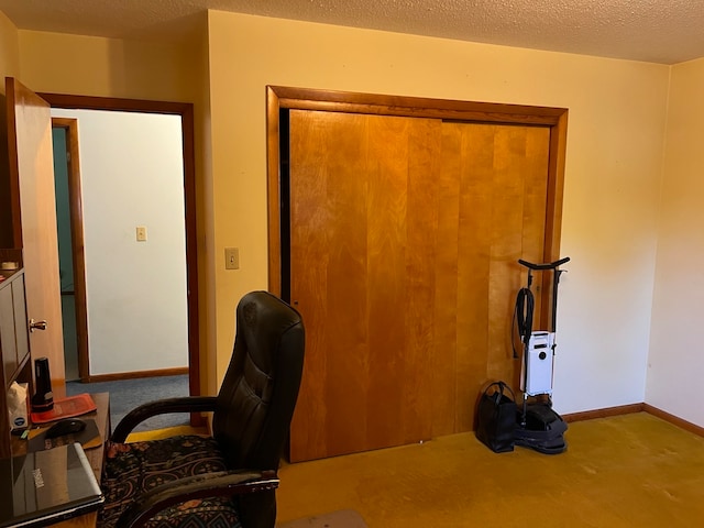 carpeted home office with a textured ceiling