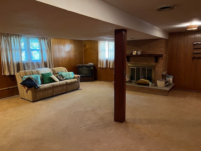 carpeted living room with wooden walls, a textured ceiling, and a fireplace