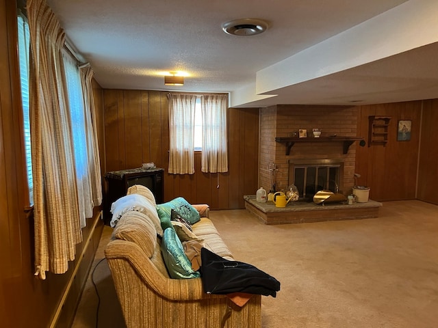 carpeted living room featuring a textured ceiling, a fireplace, and wooden walls