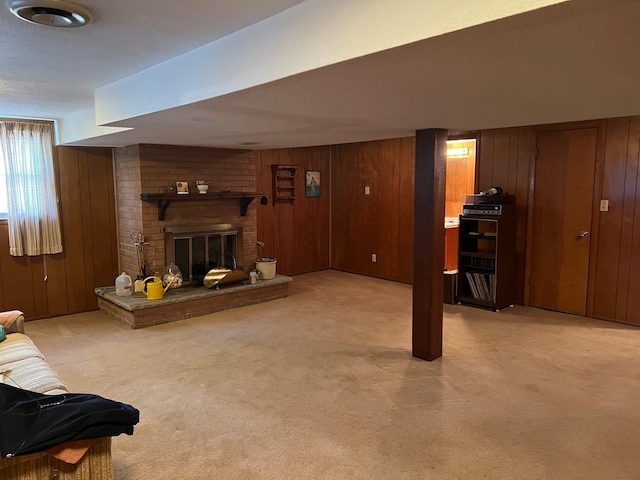 basement with a fireplace, wood walls, and light carpet