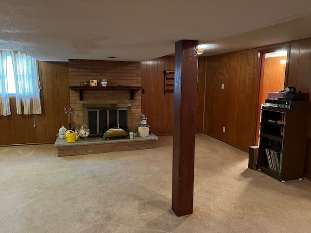 basement with light colored carpet, a textured ceiling, a fireplace, and wood walls