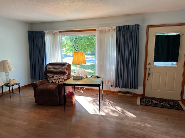 sitting room with a textured ceiling and wood-type flooring