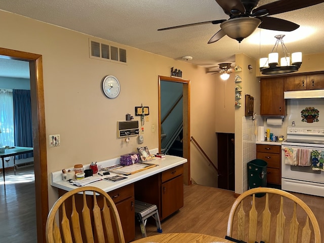 home office featuring light hardwood / wood-style floors, ceiling fan, and a textured ceiling