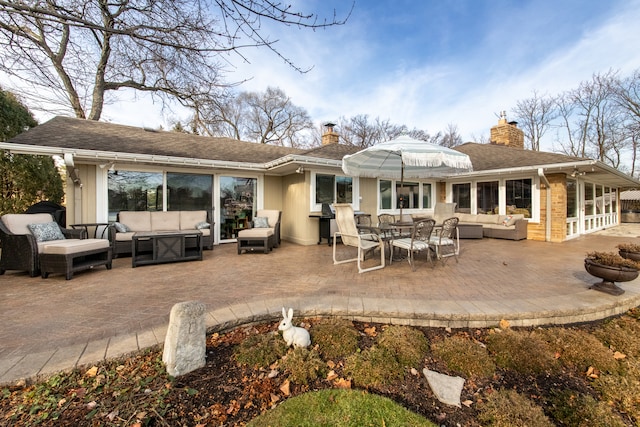 back of property with an outdoor living space and a patio area