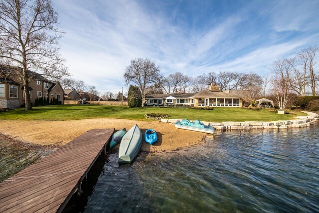 view of dock featuring a water view and a lawn