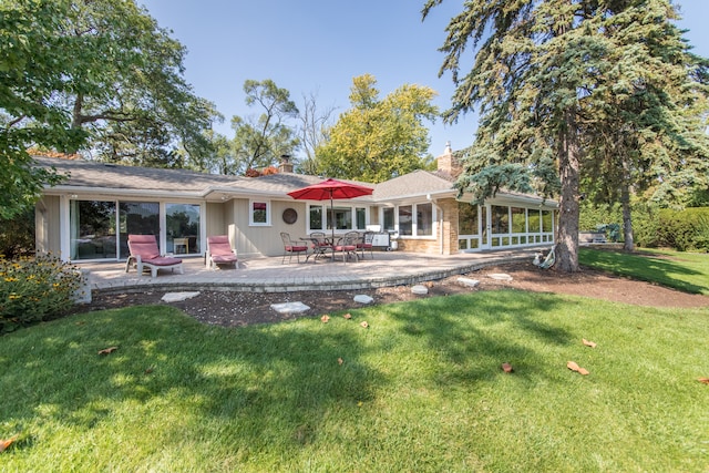 back of house with a patio area and a lawn