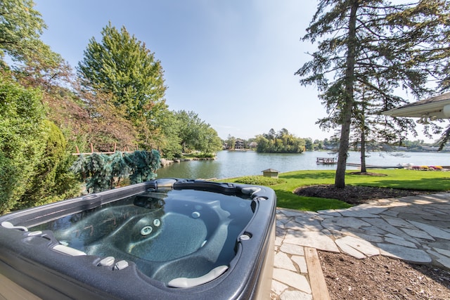 view of patio / terrace featuring a hot tub and a water view