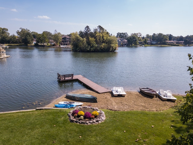 dock area with a lawn and a water view