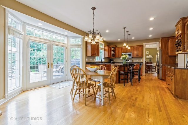 dining area with sink, light hardwood / wood-style flooring, and plenty of natural light