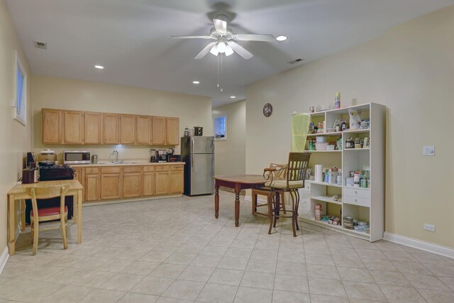 kitchen featuring appliances with stainless steel finishes, sink, light brown cabinets, light tile patterned floors, and ceiling fan