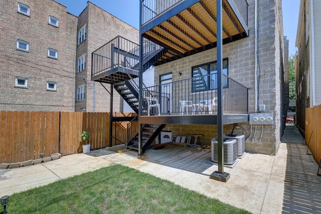 back of property with a balcony, cooling unit, and a patio area