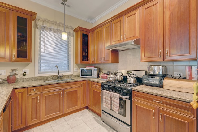 kitchen with light stone countertops, gas range oven, hanging light fixtures, and sink