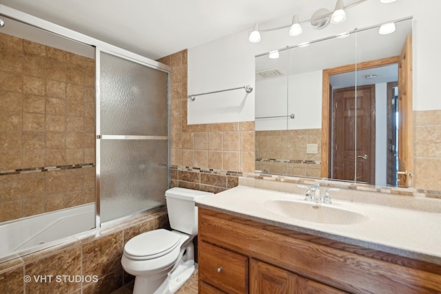 full bathroom with vanity, toilet, and tile walls