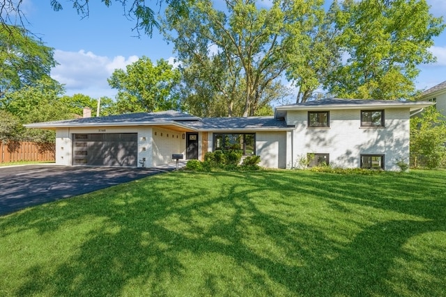 split level home featuring a garage and a front lawn