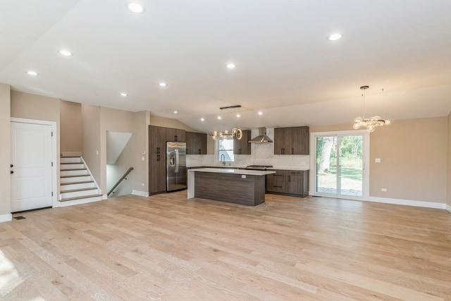 kitchen with hanging light fixtures, a kitchen island, light wood-type flooring, dark brown cabinets, and stainless steel refrigerator with ice dispenser