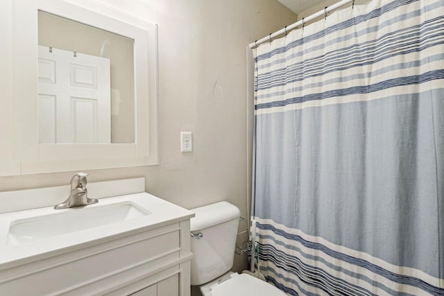 bathroom featuring vanity, curtained shower, and toilet