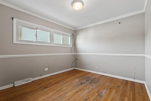 empty room with hardwood / wood-style flooring and ornamental molding