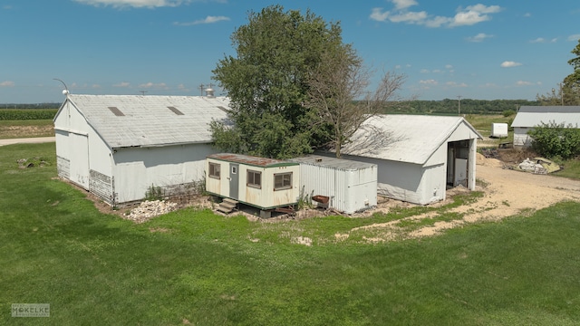 rear view of house featuring a yard and a storage shed