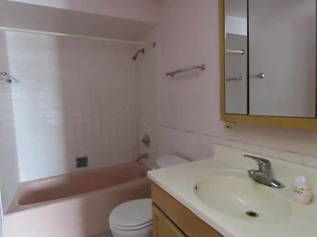 full bathroom with tiled shower / bath combo, vanity, and toilet