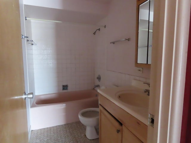 full bathroom featuring vanity, tiled shower / bath combo, and toilet