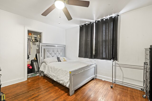 bedroom featuring hardwood / wood-style flooring, ornamental molding, a closet, and ceiling fan