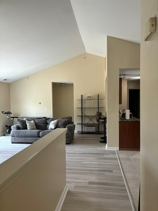 interior space with light hardwood / wood-style flooring and vaulted ceiling