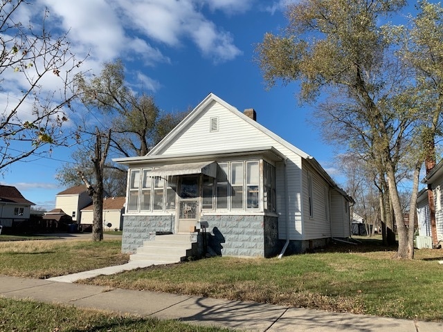 bungalow featuring a front yard and a sunroom