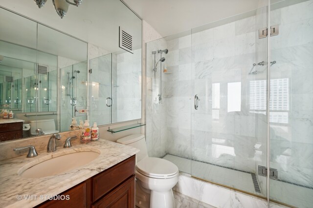 bathroom featuring an enclosed shower, vanity, tile walls, and toilet