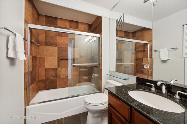 full bathroom with toilet, tile patterned floors, vanity, and bath / shower combo with glass door