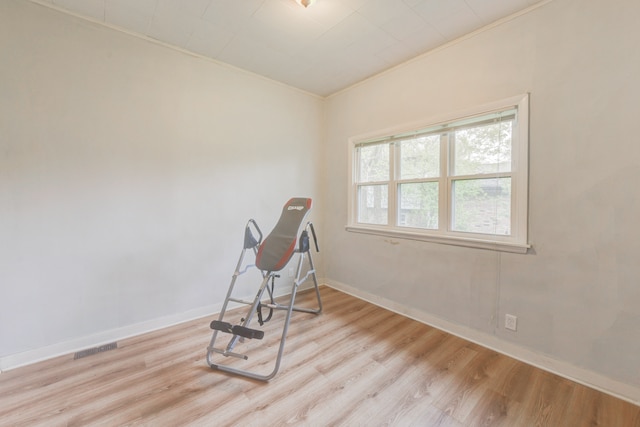 interior space with ornamental molding and light wood-type flooring